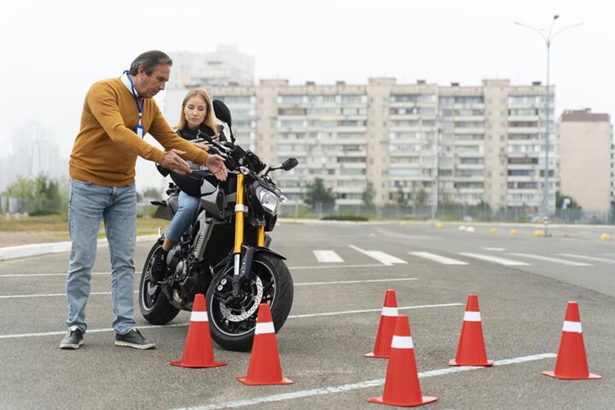 a man and a woman on a motorcycle between orange cones