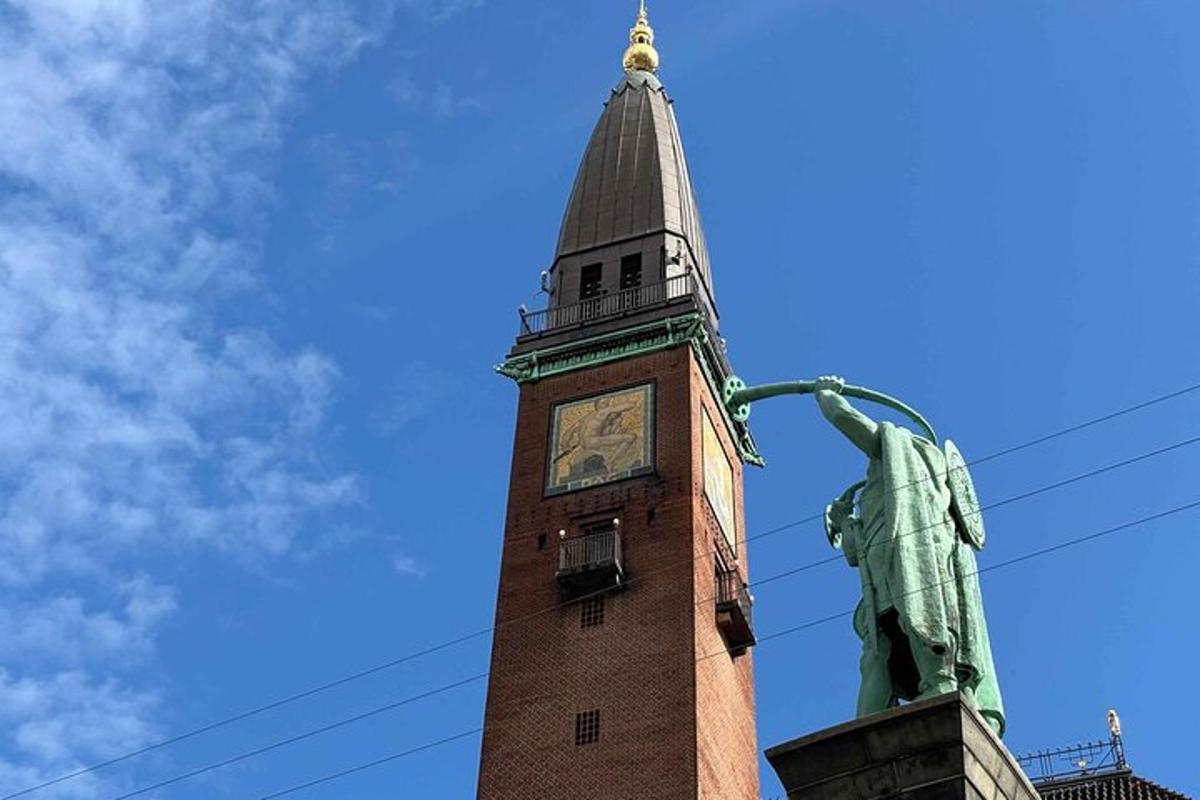 un turn cu ceas cu o statuie în fața lui