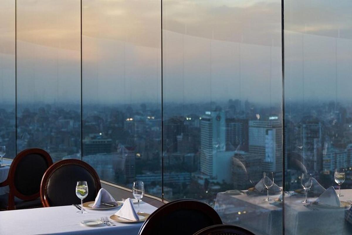 a table with wine glasses and a view of a city