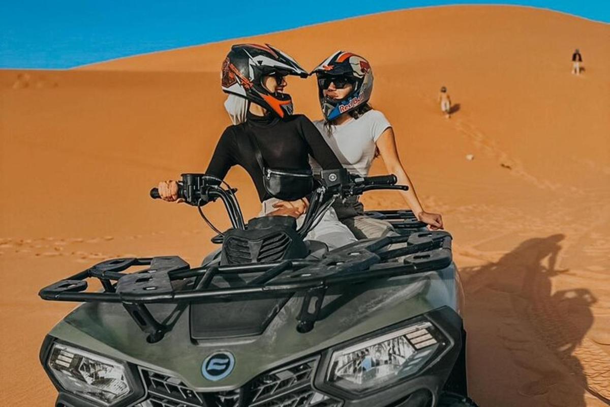 شخصان يركبان دراجة رباعية في الصحراء