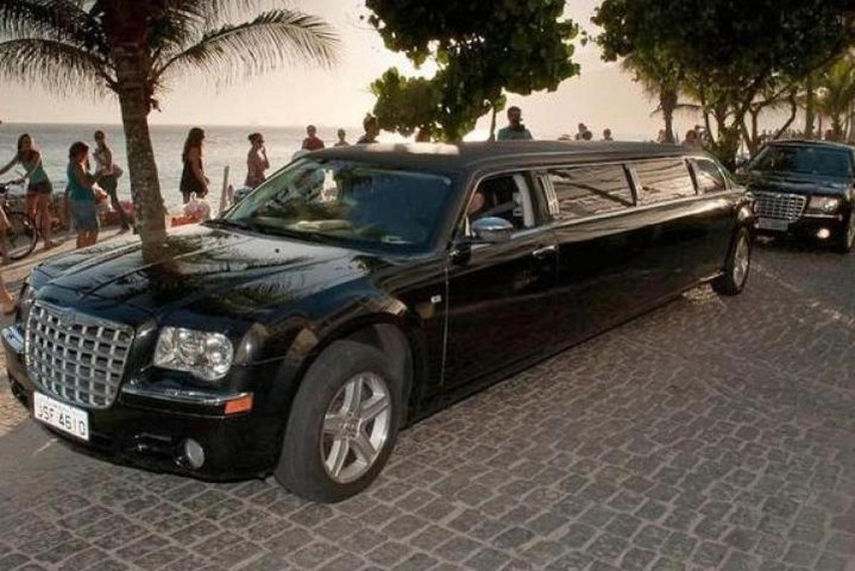 a limo parked on a street next to a beach
