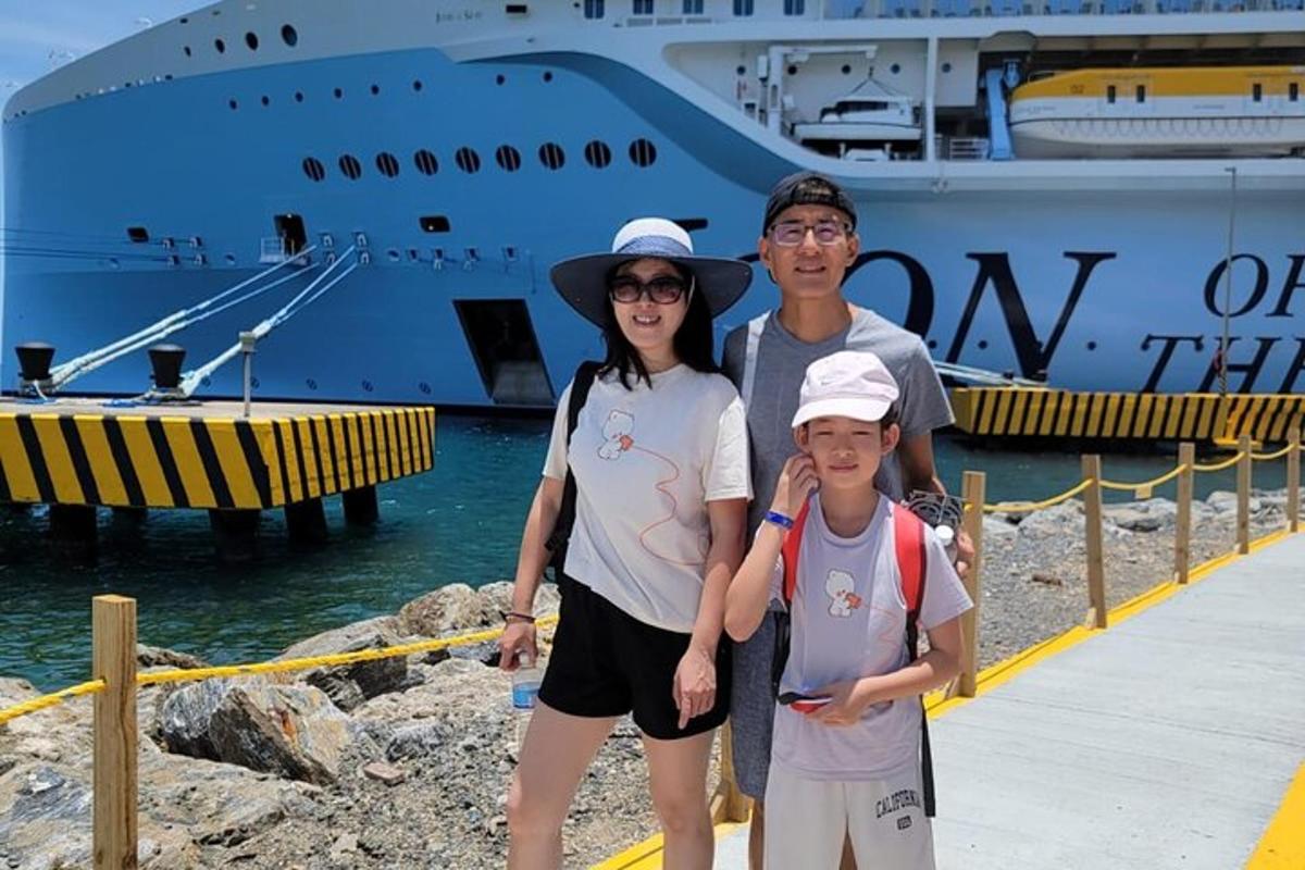 a family posing in front of a cruise ship
