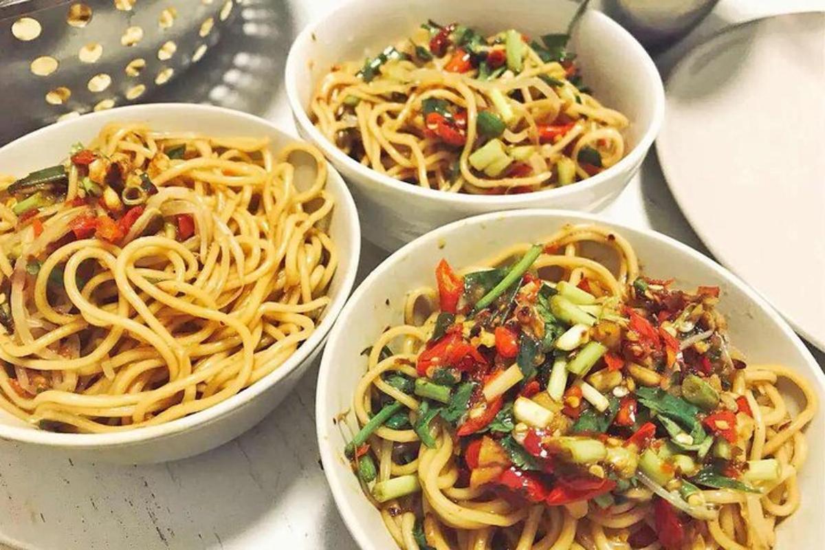 four bowls of pasta with vegetables in them on a table