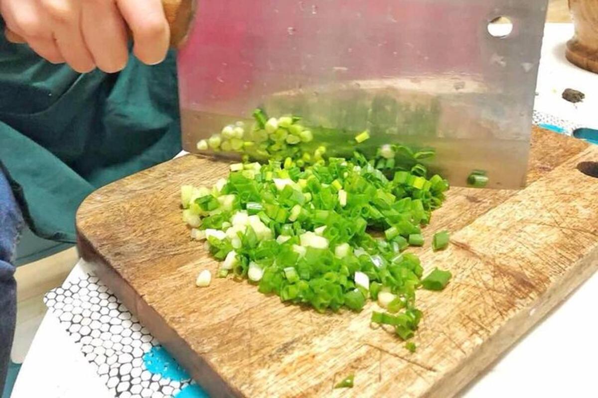 一个人在砧板上切葱