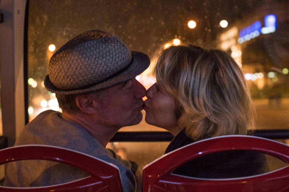a man and a woman sitting in chairs kissing