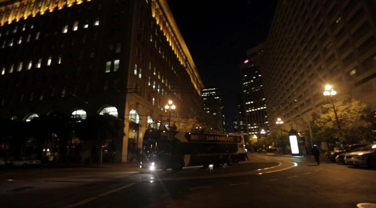 a bus driving down a city street at night