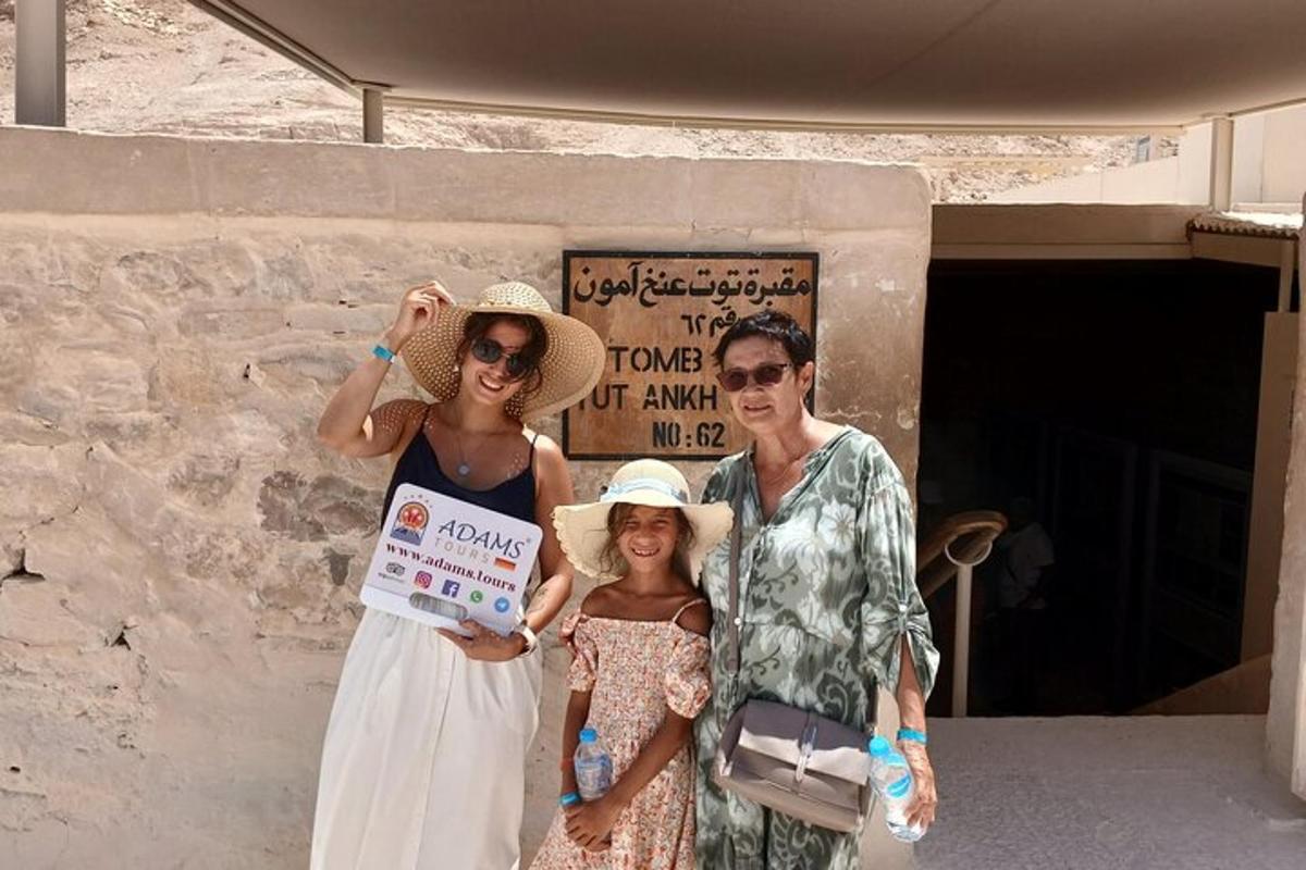 Μια οικογένεια ποζάρει για μια φωτογραφία μπροστά σε ένα κτίριο