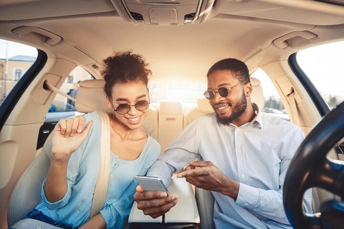 a man and a woman sitting in the back of a car