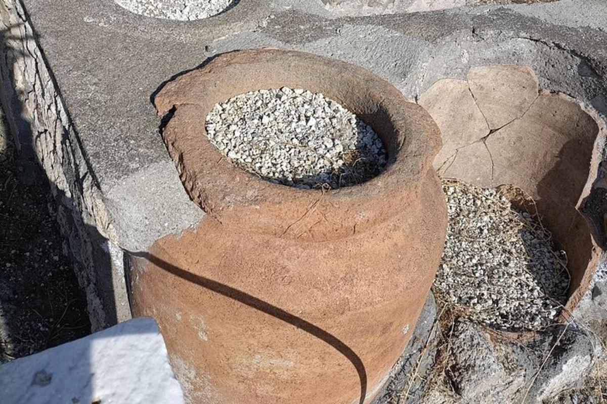 eine mit Kies gefüllte Vase auf dem Boden