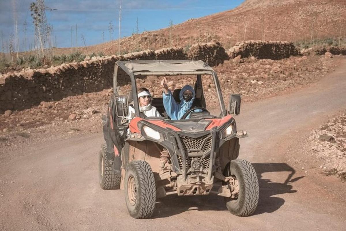 two people in a four wheeler on a dirt road