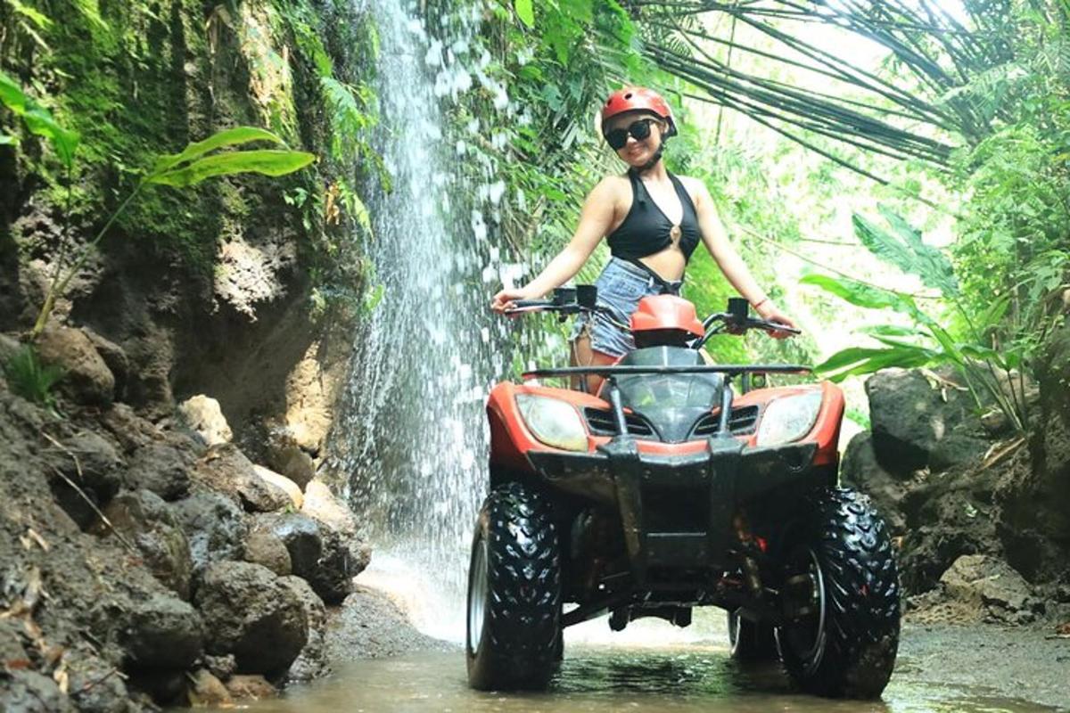 seorang wanita di atv di hadapan air terjun