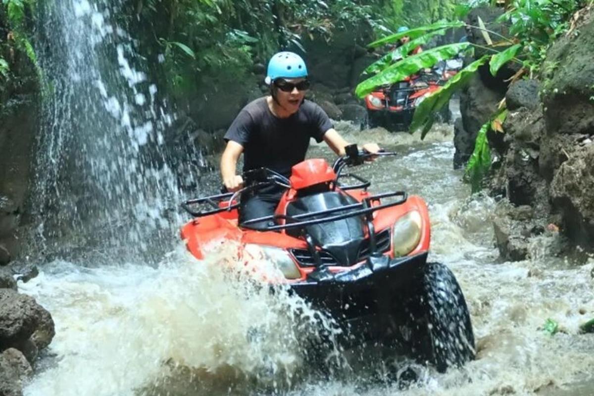 seorang lelaki menaiki atv melalui air terjun