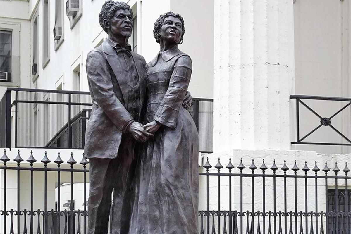 a statue of a man and a woman standing in front of a building