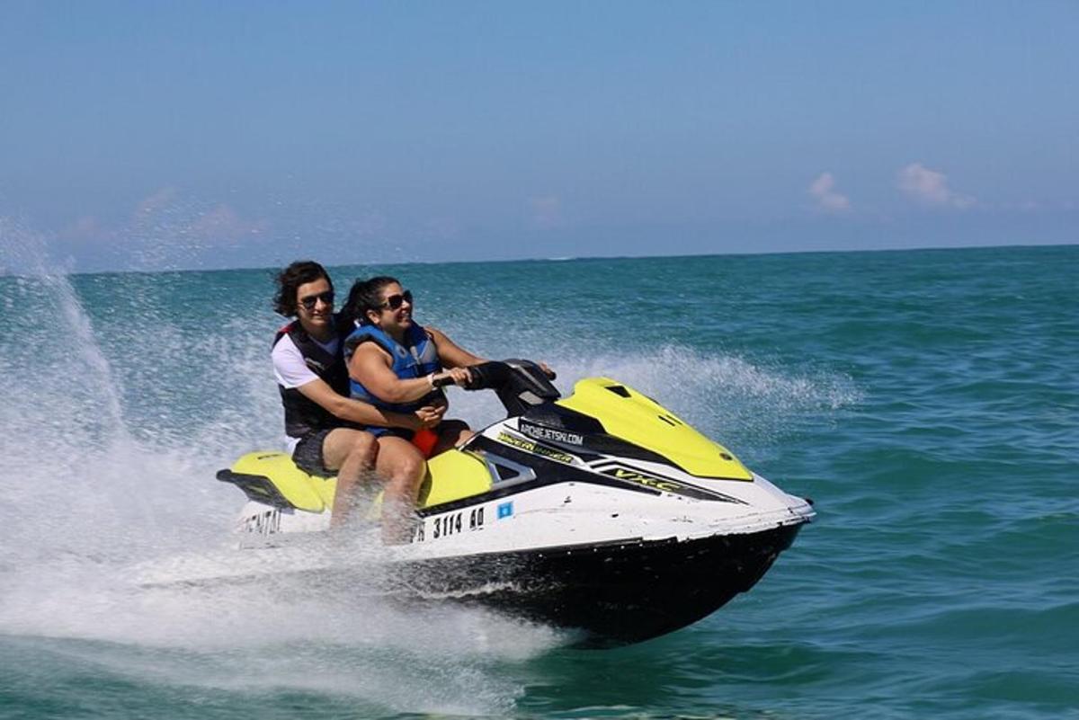 drei Personen fahren auf einem Jetski im Wasser