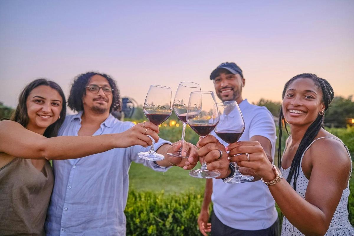 un gruppo di persone che sorreggono bicchieri di vino
