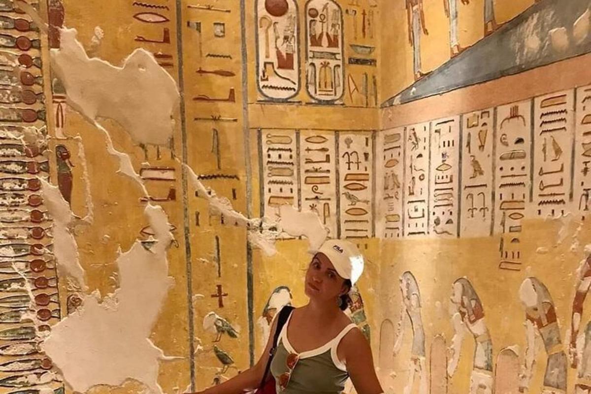 una donna in piedi davanti a un muro con una scritta sopra