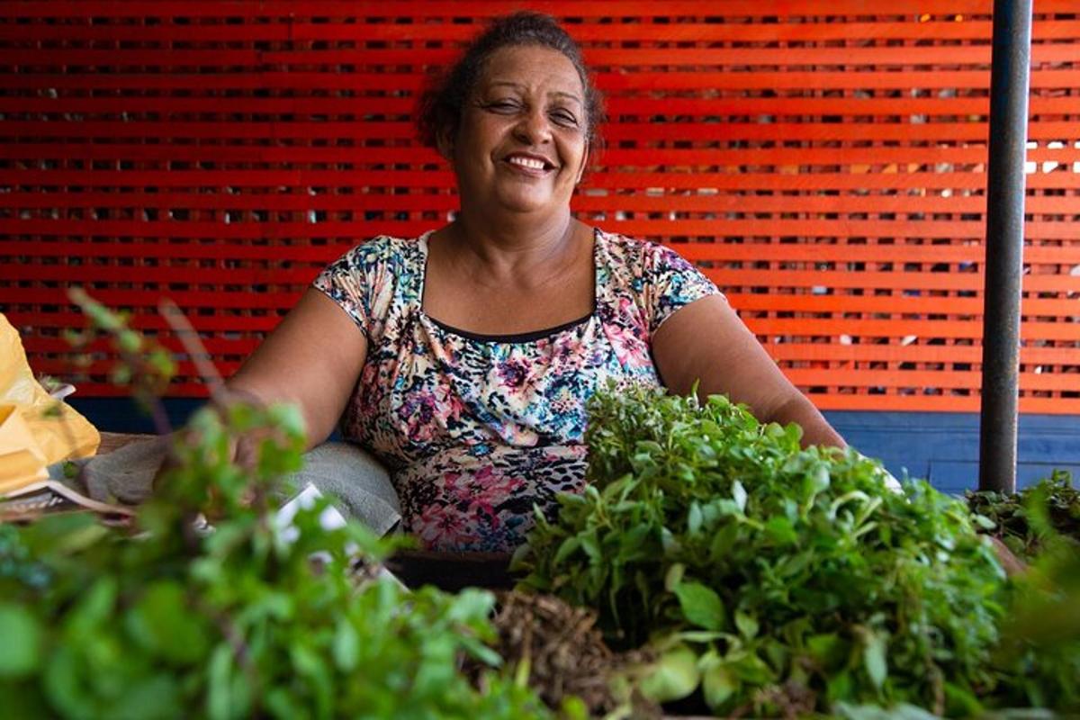a woman sitting at a table with potted plants