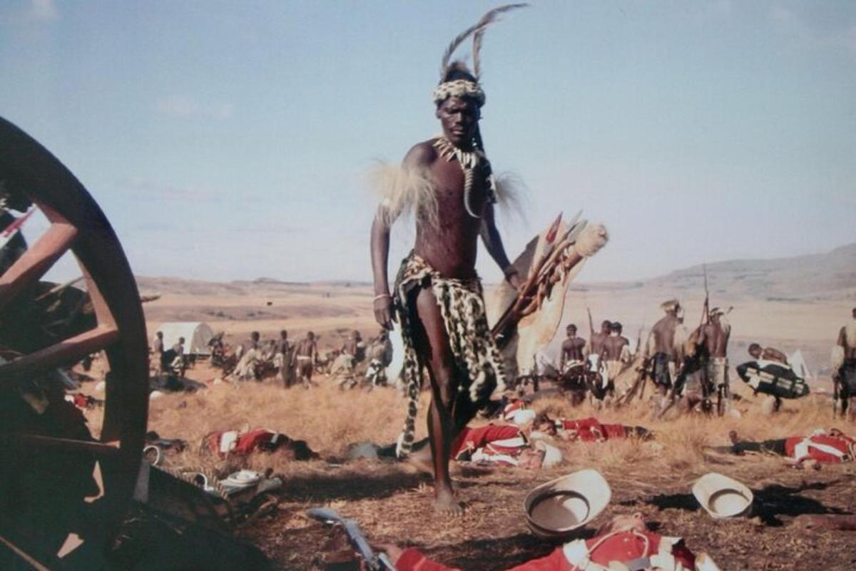 Un hombre parado en un campo con un grupo de personas.