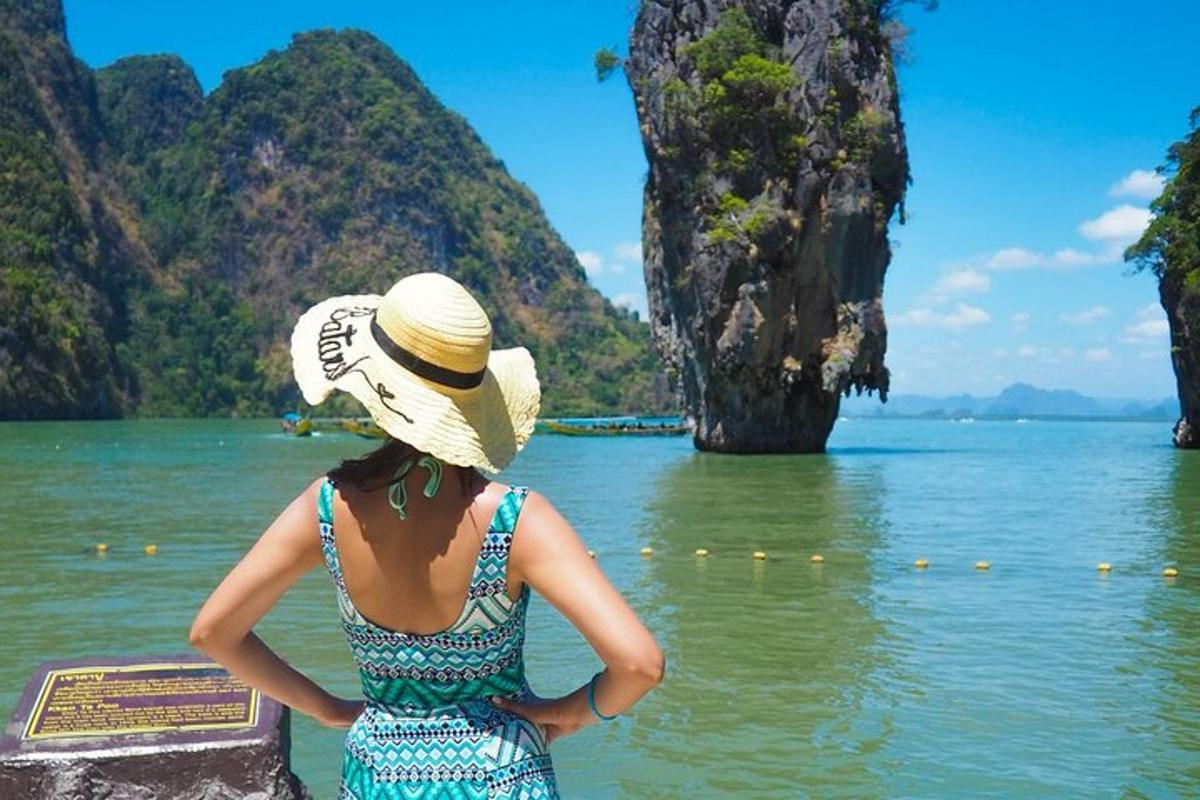 Una mujer con sombrero mira el agua.