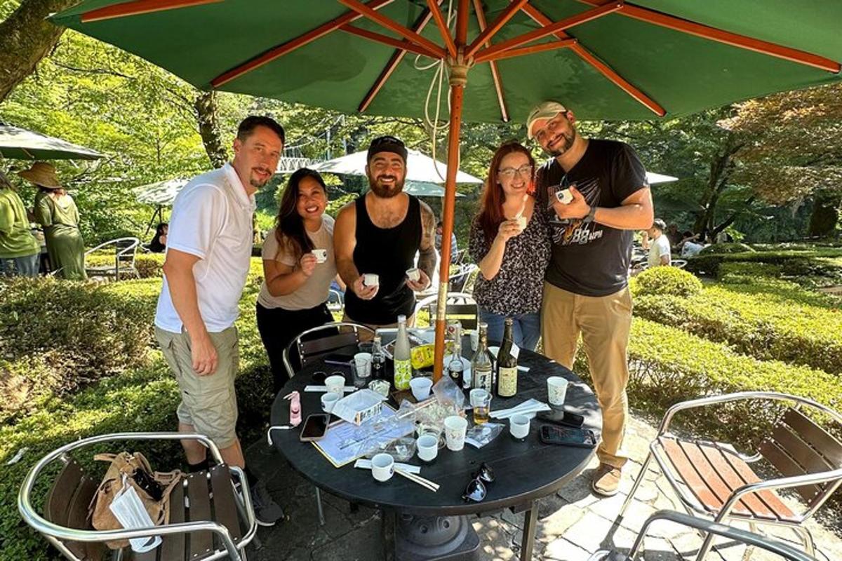 a group of people standing around a table with an umbrella