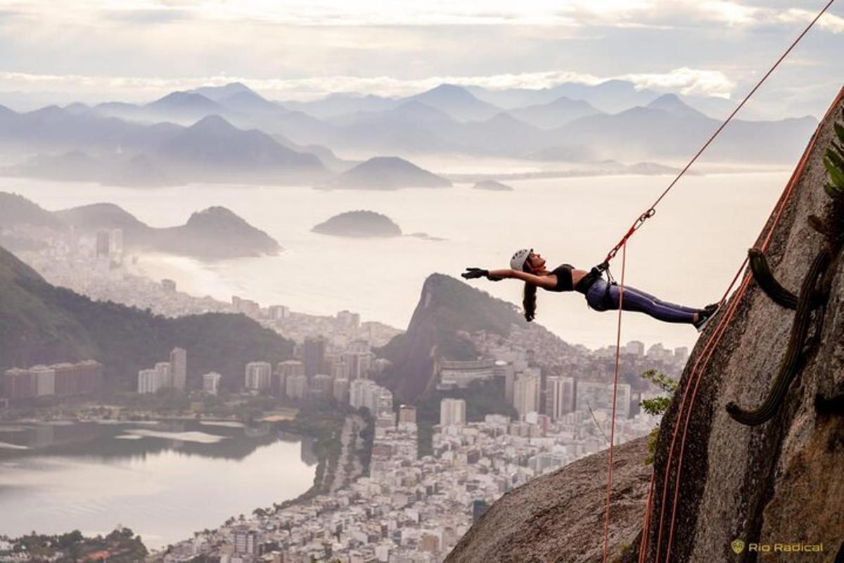 uma pessoa pendurada em uma corda enquanto escala uma rocha