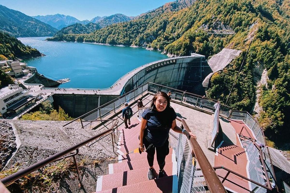 egy nő áll a tópartra néző lépcsőn