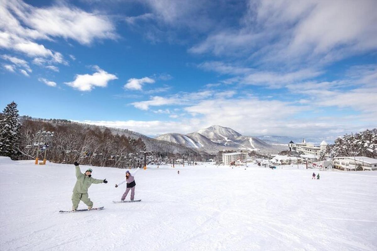 két ember snowboardozik a hóban egy sípályán