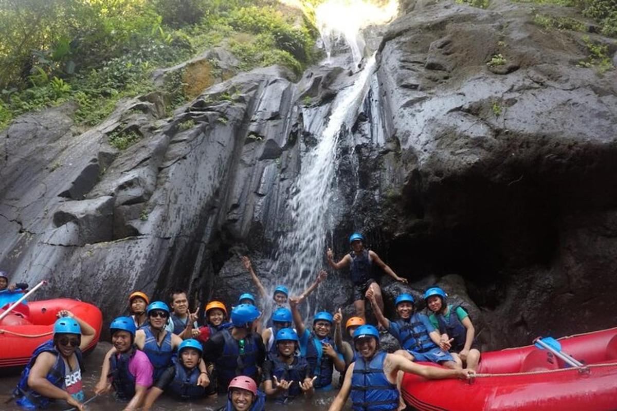 a group of people posing in front of a waterfall