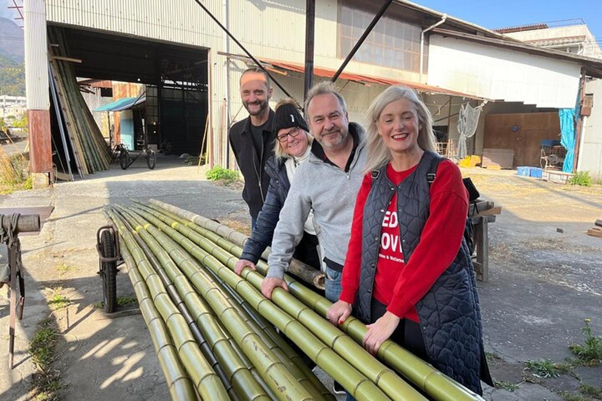 a group of people standing next to a pile of bamboo