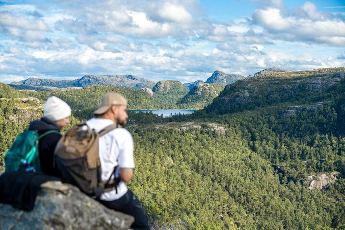 two people sitting on top of a rock overlooking a valley