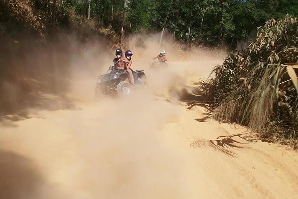 un grup de oameni care călătoresc cu ATV-uri pe un drum de pământ