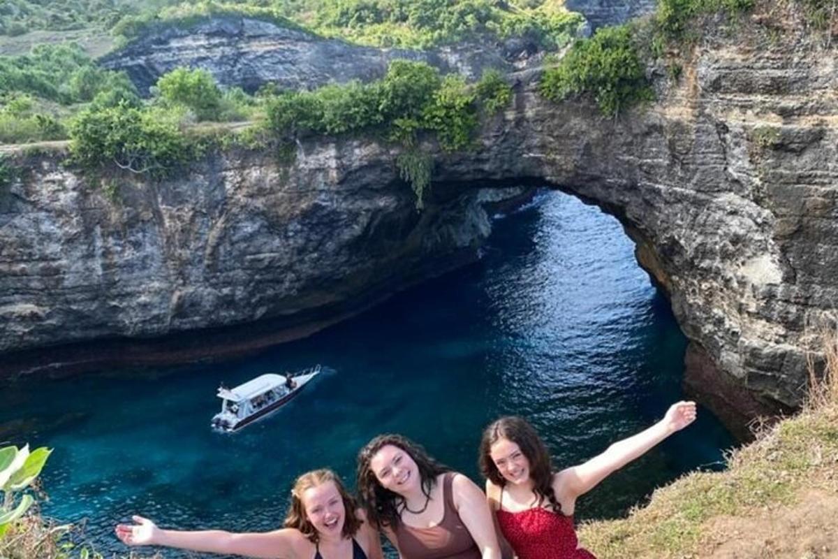 Tři dívky pózují před jeskyní s lodí