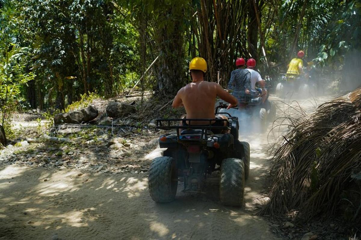 un grup de oameni care călătoresc pe ATV-uri pe un drum de pământ