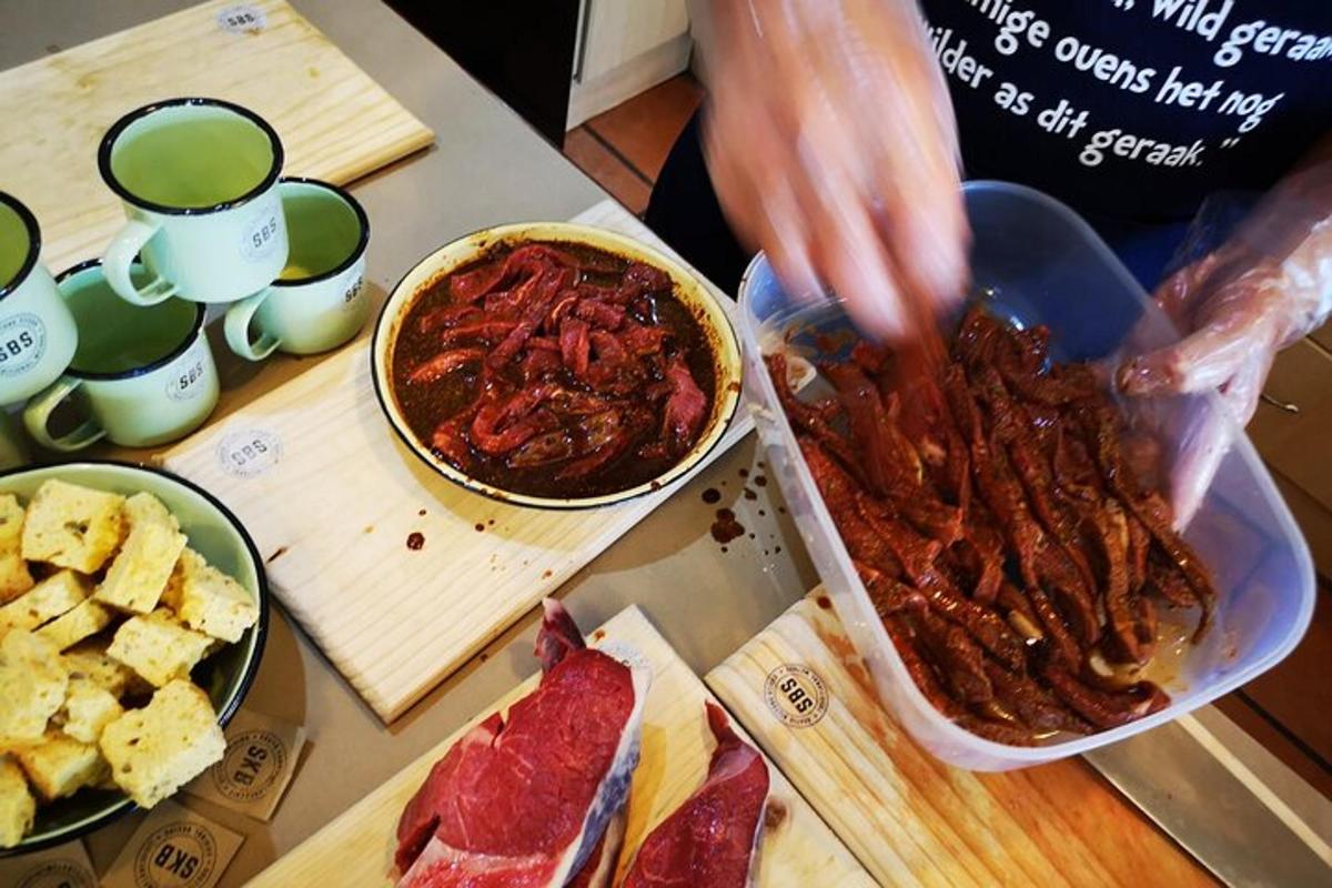 Una persona está preparando comida en una mesa con carnes.