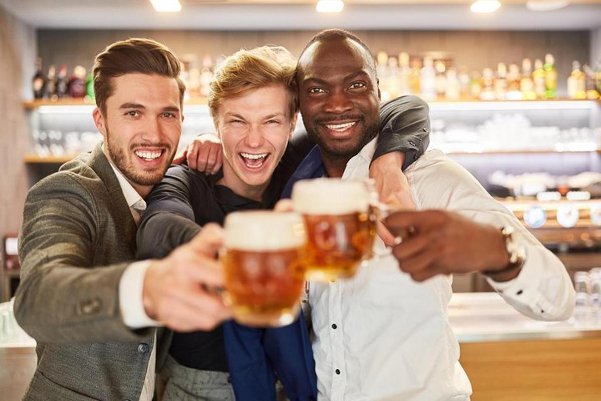 skupina čtyř mužů pijících pivo v hospodě