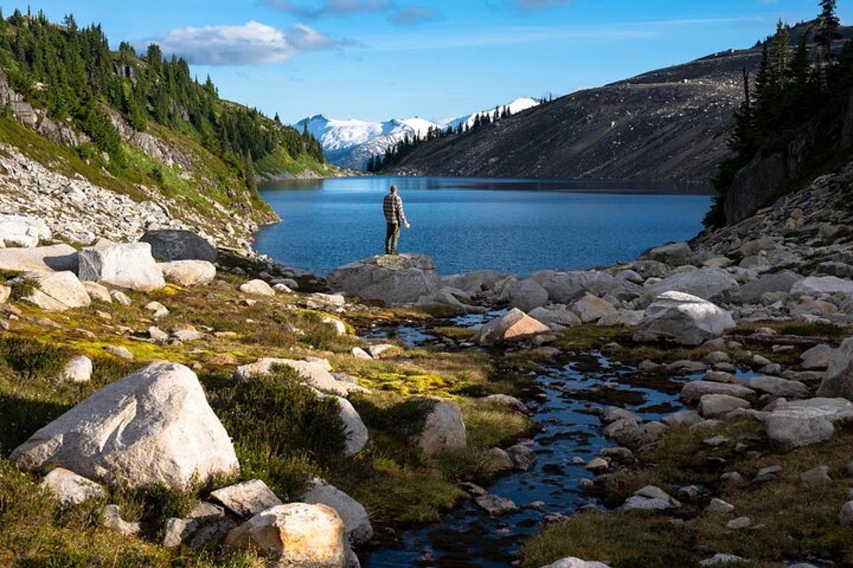 a man standing on a rock near a lake