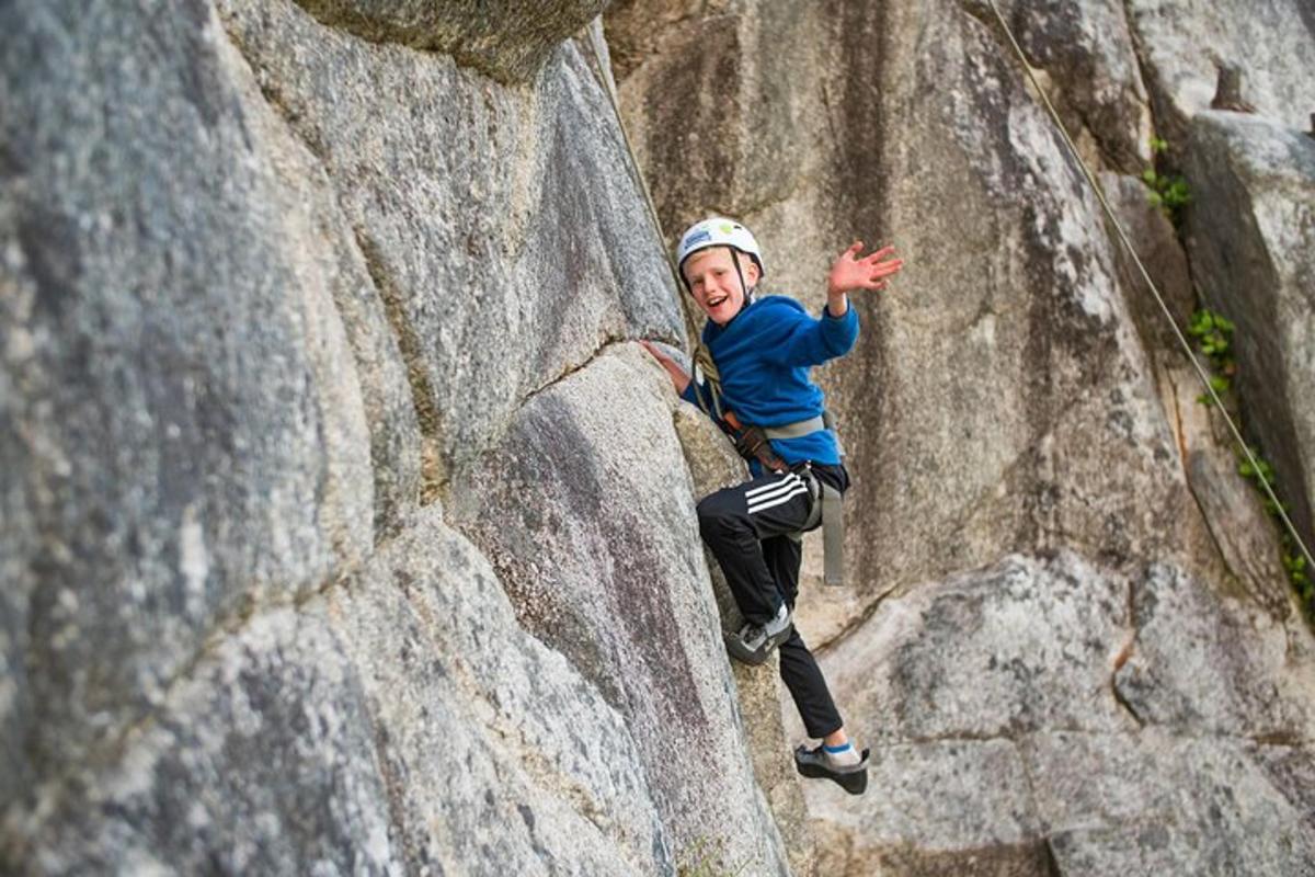 a young boy is climbing a rock wall