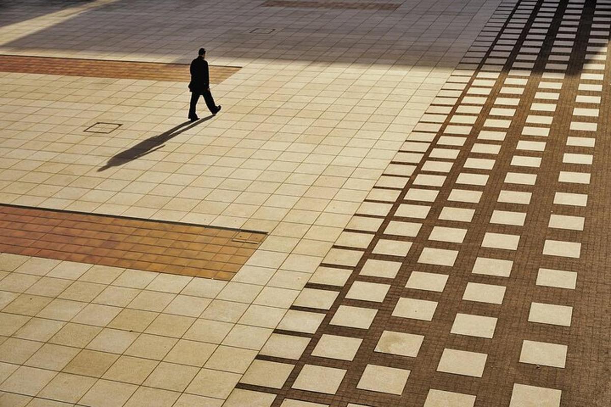 isang lalaking naglalakad sa tiled sidewalk