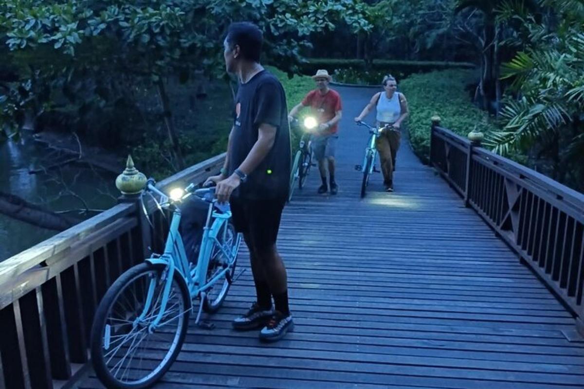muž stojaci na moste s bicyklom