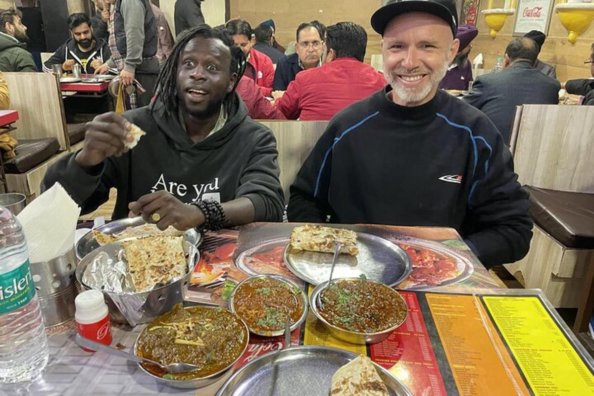 two men sitting at a table with plates of food