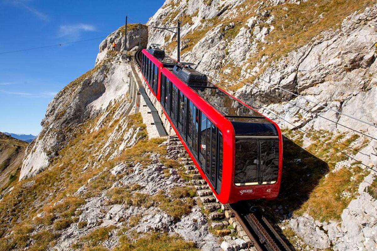 isang pulang tren sa mga riles sa isang bundok