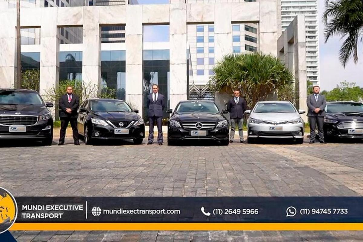 a group of men standing inront of parked cars