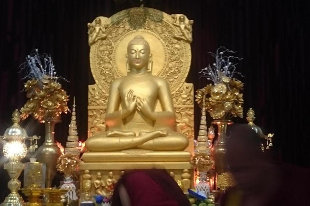 o statuie de aur a unei femei așezate în meditație