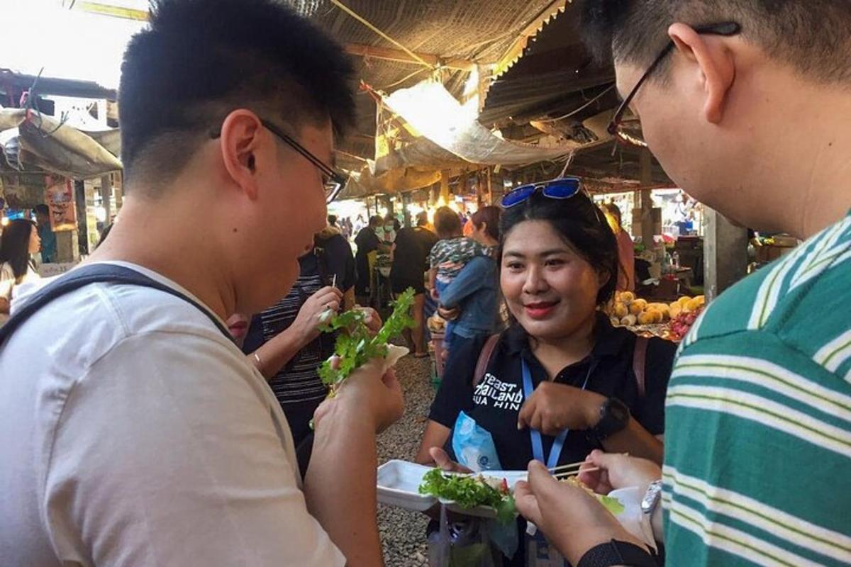 a group of people eating food at a market