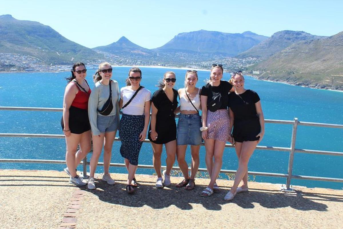 eine Gruppe von Frauen steht auf einem Zaun in der Nähe des Wassers