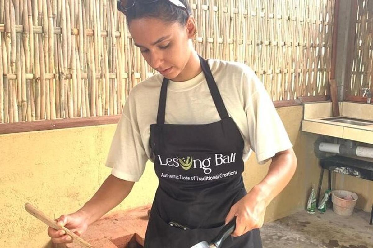 Una mujer con delantal preparando comida en una cocina.