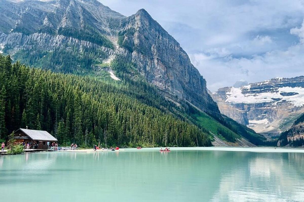 Un lago frente a una montaña con gente en él.