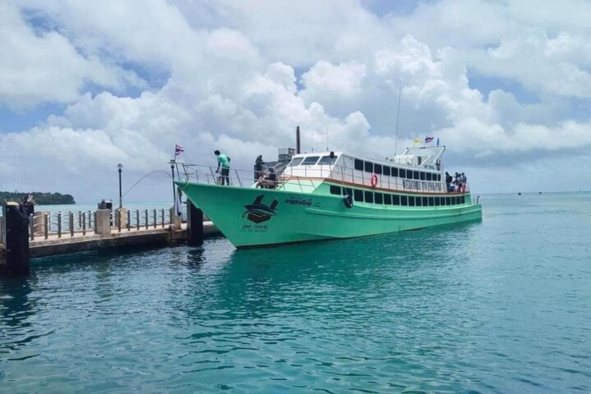 a green and white boat parked at a dock