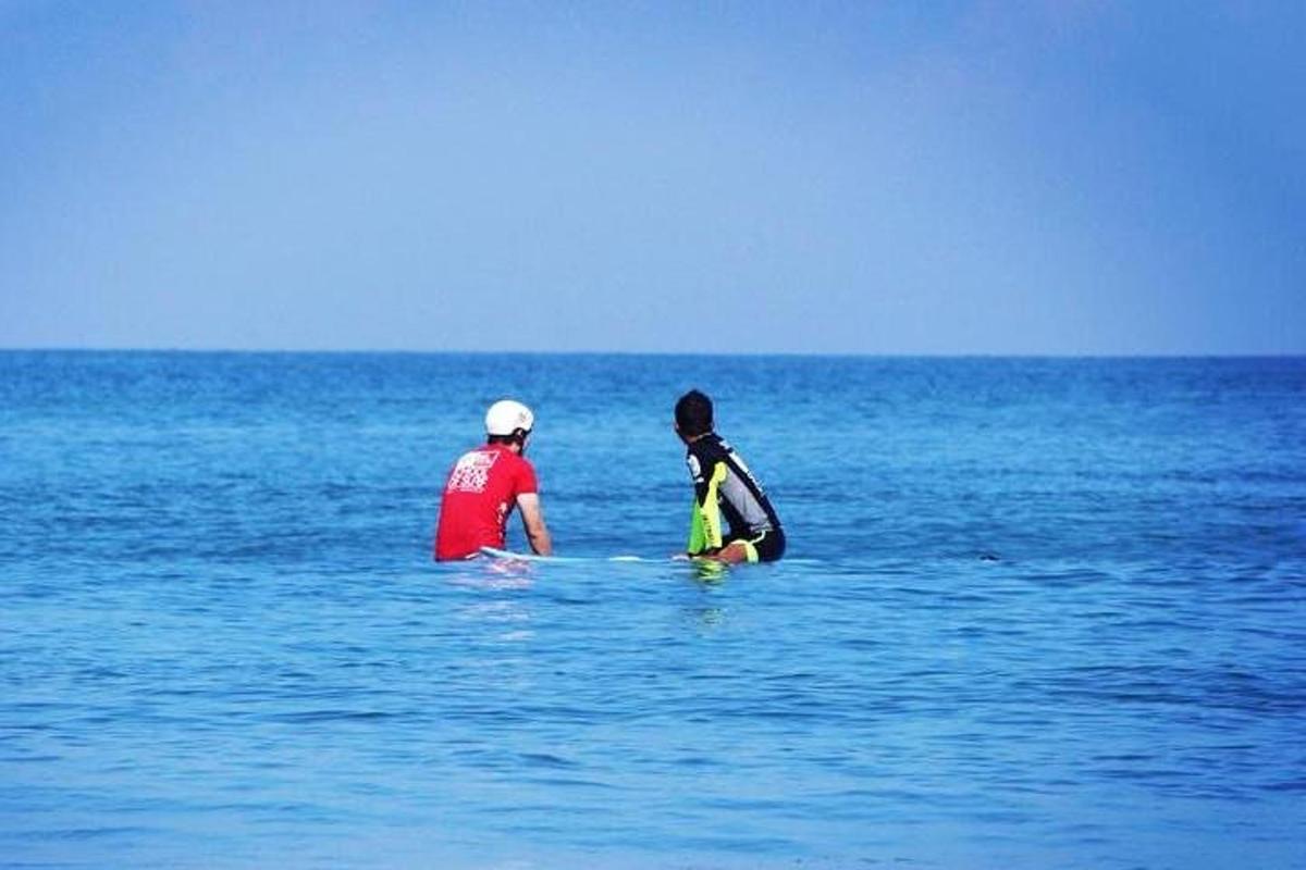 to personer sitter i vannet i havet