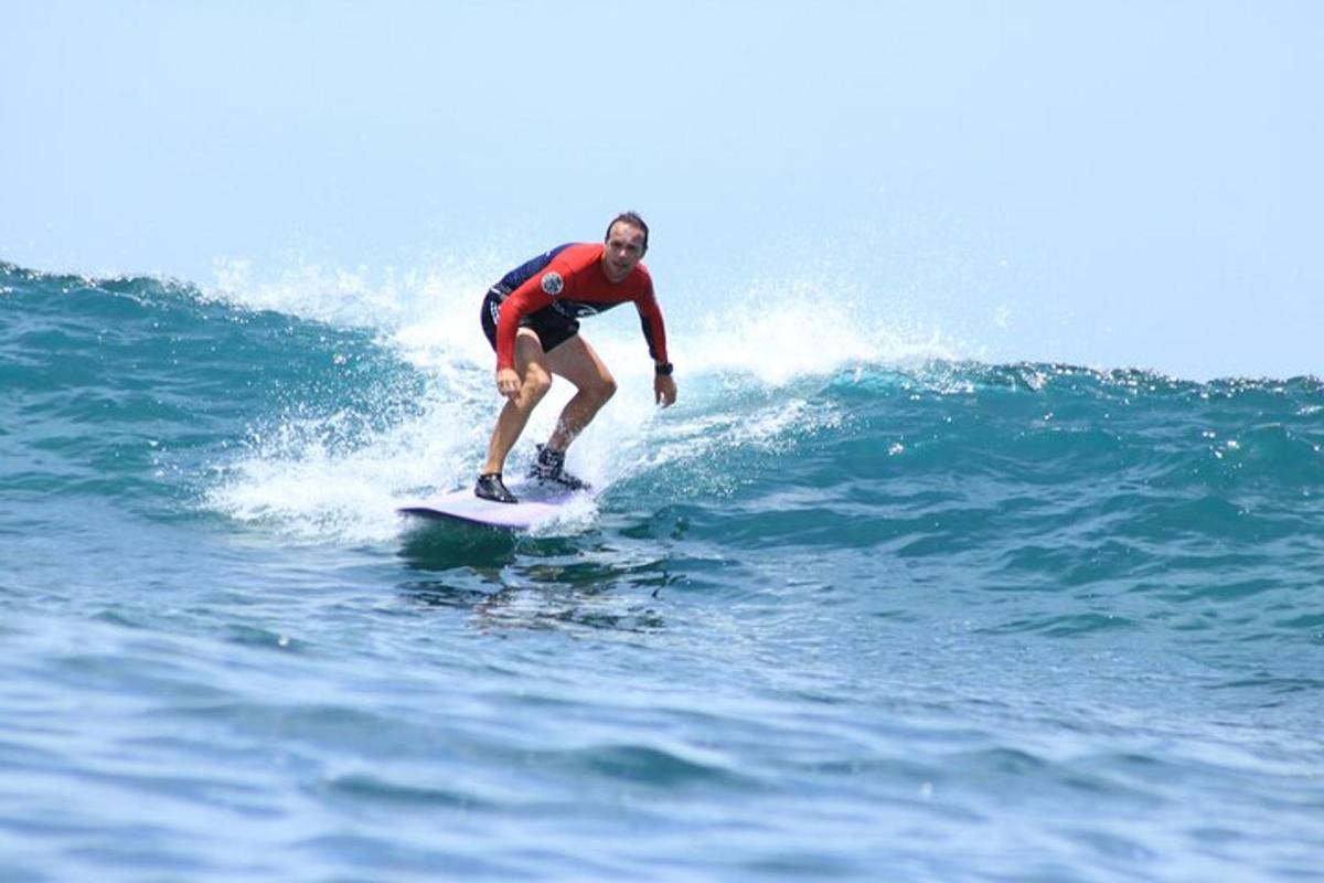 mężczyzna jadący na desce surfingowej na fali w oceanie